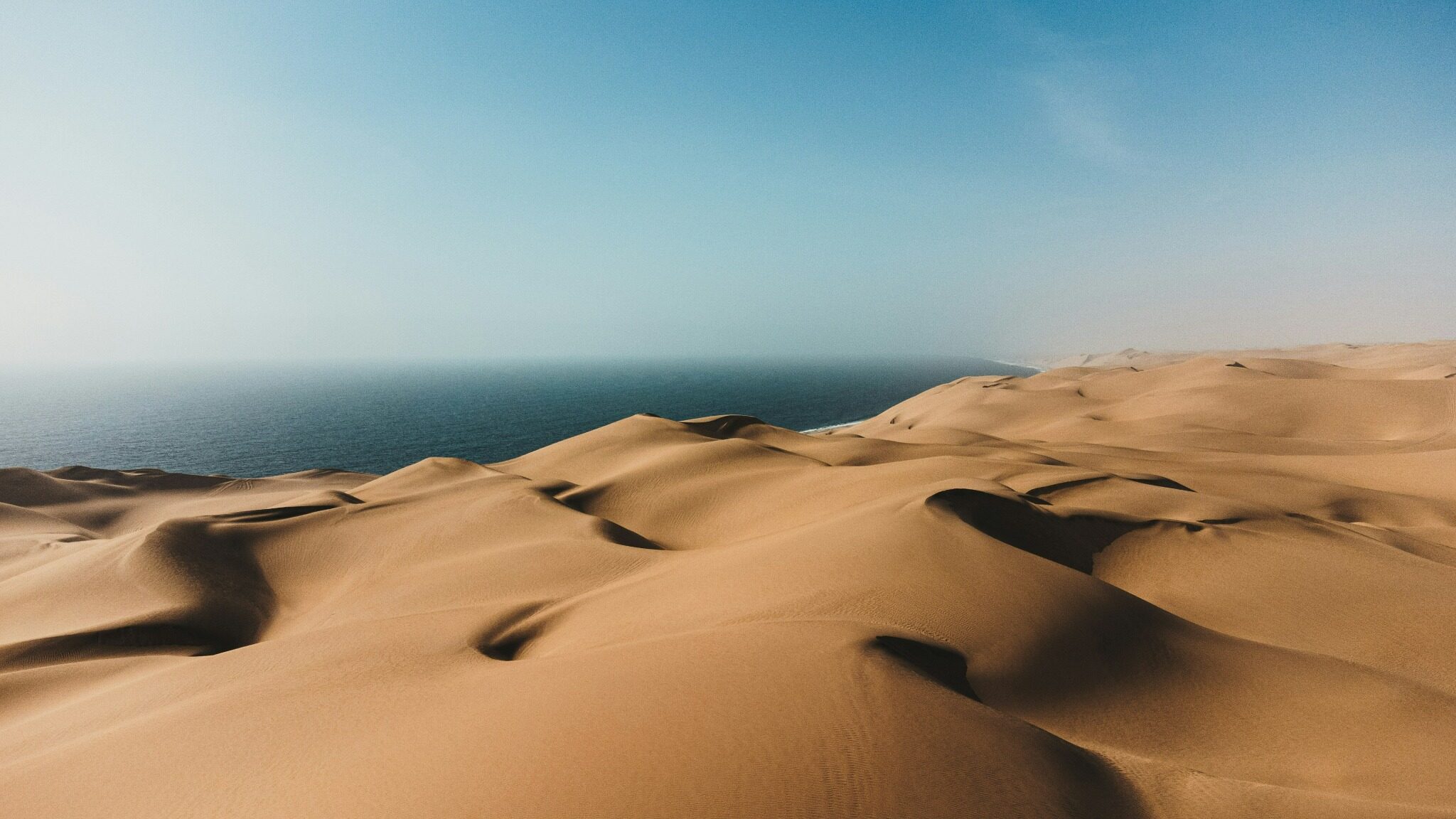 Sand dunes meeting the Atlantic Ocean at Sandwich Harbour, Namibia